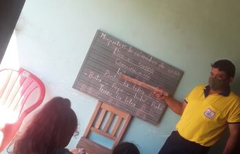 El docente les deja copiada la tarea en la pizarra.