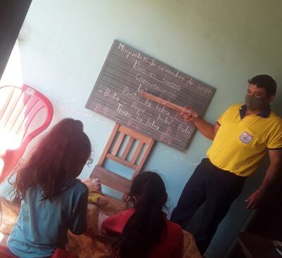 El docente les deja copiada la tarea en la pizarra.