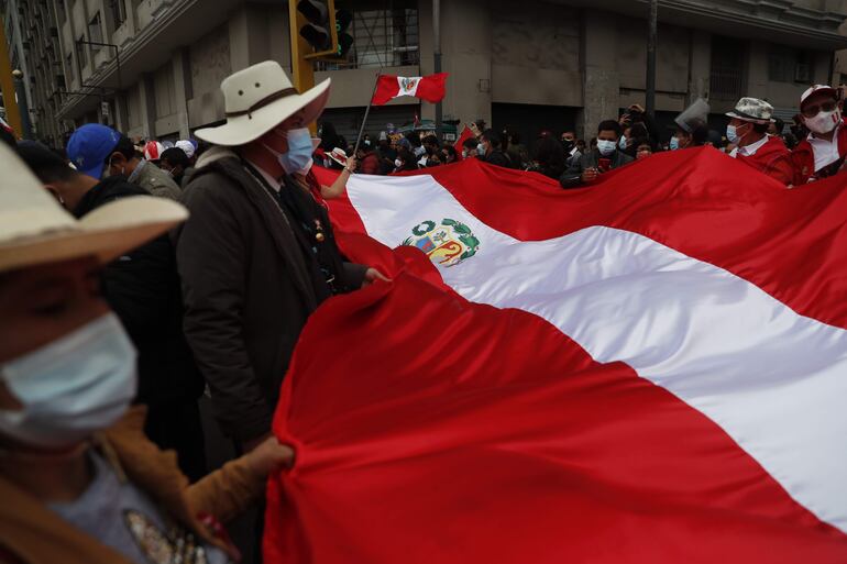 Simpatizantes del presidente entrante del Perú, Pedro Castillo, siguen la ceremonia de Investidura en las afueras de la sede del Congreso hoy, en Lima.
