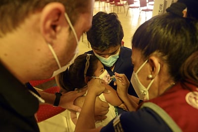 Aunque la mayoría recibe con emoción el antiviral, muchos niños deben ser asistidos para ser inmunizados.