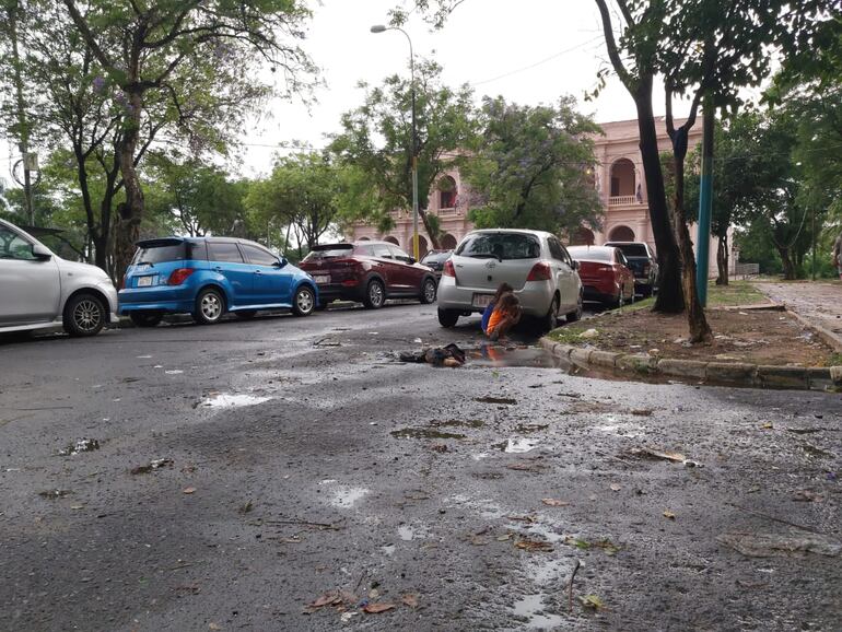 Niñas cepillándose los dientes con agua que sale de un caño roto