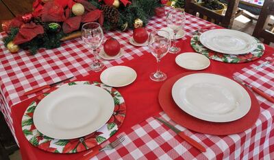 Esta puesta de mesa lleva un mantel a cuadros, y fusión de posaplatos.