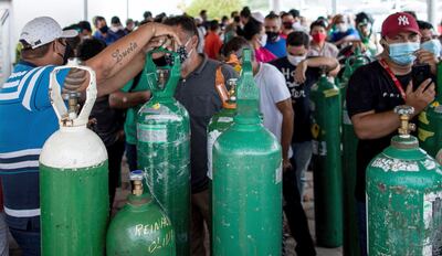 Familiares de pacientes con covid-19 esperan horas para abastecer sus cilindros de oxígeno.