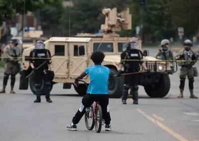 Un hombre se detiene con su bicicleta frente a un puesto de control en Minneapolis, Minnesota.