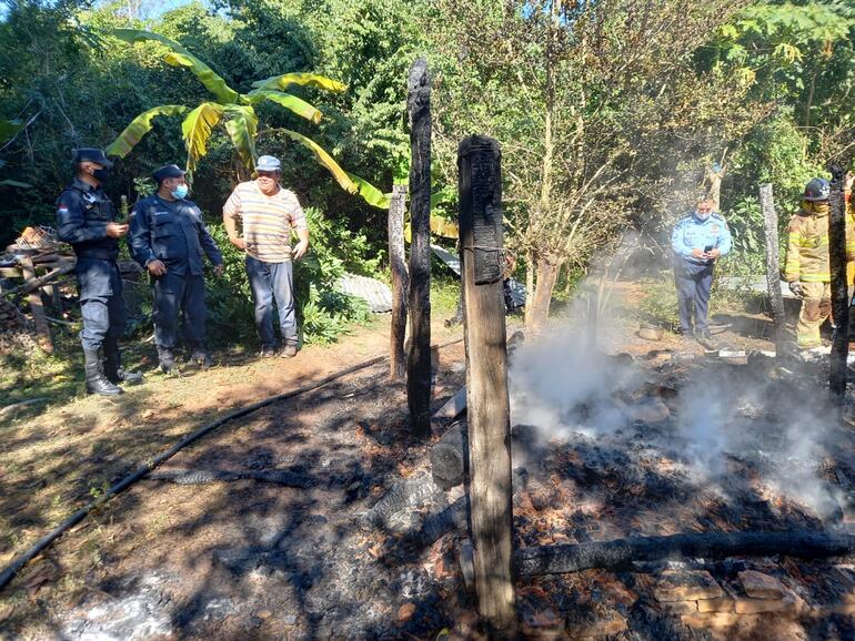 Policías y un vecino contemplan las pérdidas materiales.