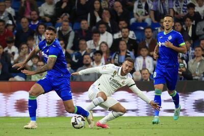 El delantero belga del Real Madrid, Eden Hazard (c), disputa el balón ante el defensa paraguayo del Getafe, Omar Alderete, durante el encuentro correspondiente a la jornada 34 de primera división disputado ayer sábado en el estadio Santiago Bernabéu, en Madrid. EFE / Zipi Aragón.