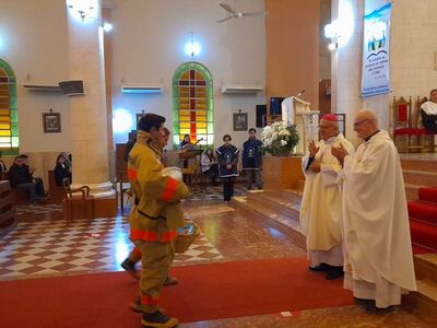 El obispo de la diócesis de Carapeguá, Celestino Ocampos, y el párroco Gianluigi Arofo reciben las ofrendas de los Bomberos Voluntarios de Pilar.
