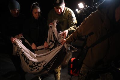 Varias personas cargan con el cuerpo sin vida de un perro en el lugar de un ataque con misiles al centro de Kiev (Ucrania), este jueves. Al menos dos misiles han caído en la calle Tatarskaya de Kiev, en el distrito de Shevchenkivskyi. Según han dicho a Efe testigos presenciales, una de ellas ha impactado en un edificio residencial. En ese edificio vive junto a su abuela y sus dos hijos una joven llamada Marina Zdanovich, de 31 años, que ha dicho a Efe que según sus vecinos la casa ha quedado dañada. Su abuela, que estaba en el interior, ha resultado herida leve, según ha explicado a Efe. El otro misil ha caído sobre una empresa llamada Artem, a la que al parecer iba dirigido el ataque, por tratarse de una fábrica de misiles. EFE/ Miguel Gutiérrez