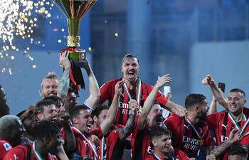 La figura de Ibrahimovic emerge en el grupo de jugadores del AC Milan festejando con el trofeo.