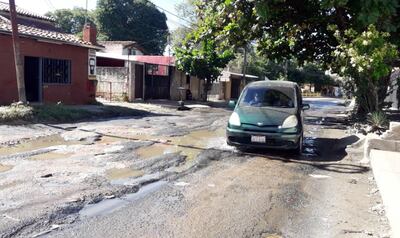 Un auto debe transitar en sentido contrario para eludir los baches de la calle San Rafael.