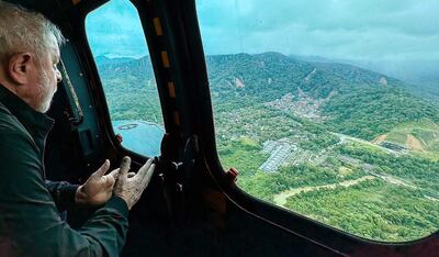 Fotografía cedida por Presidencia de Brasil, del presidente de Brasil, Luiz Inácio Lula da Silva, mientras observa las áreas afectadas por la lluvia durante un sobrevuelo hoy en Sao Sebastiao (Brasil).