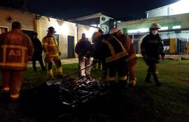 Bomberos luego de aplacar el fuego que se generó en el patio de una capilla.