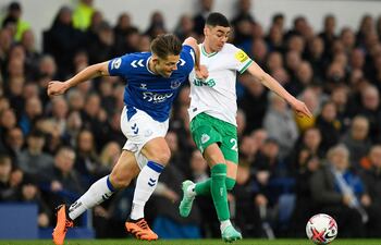 Miguel Almirón (d) disputa el balón con James Tarkowski, defensor del Everton, durante el duelo que Newcastle ganó ayer por 4-1.