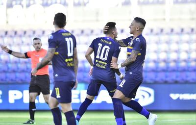 Alex Álvarez (i) celebra el único gol de la victoria de Trinidense ante Nacional, junto a Lucas Barrios.