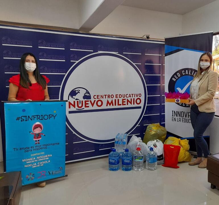 Mónica Noguera y Ada Carolina Ayala reciben los donativos del Centro Educativo Nuevo Milenio y los directivo recibieron la bandeja de dulces por el gesto de solidaridad.