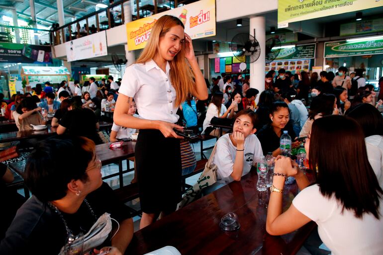 Siwakorn Thatsanasorn conversa con otros estudiantes durante el almuerzo en el campus de la universidad.