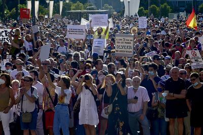 La gente se reúne portando pancartas y gritando consignas durante una manifestación contra el uso obligatorio de mascarillas y otras medidas adoptadas por el gobierno español para luchar contra el coronavirus en España, el 16 de agosto de 2020, en la plaza Colón de Madrid.