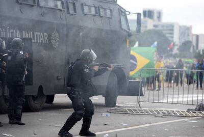 Policías antidisturbios se enfrentan a manifestantes fuera del Palacio de Planalto, en Brasilia, el domingo.