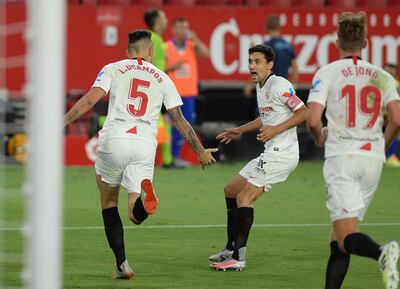 Sevilla's Argentinian midfielder Lucas Ocampos celebrates scoring a goal with Sevilla's Spanish midfielder Jesus Navas during the Spanish League football match between Sevilla FC and SD Eibar at the Ramon Sanchez Pizjuan stadium in Seville on July 6, 2020. (Photo by CRISTINA QUICLER / AFP)