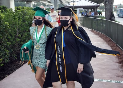 Estudiantes llegan para celebrar su graduación universitaria en el parque Magic Kingdon, en Walt Disney World de Orlando, Florida.