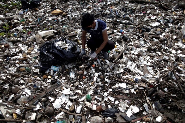 Un voluntario recoge basuras durante la jornada de limpieza.