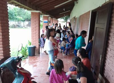 Alumnos y padres de familias esperan en los corredores de la institución.