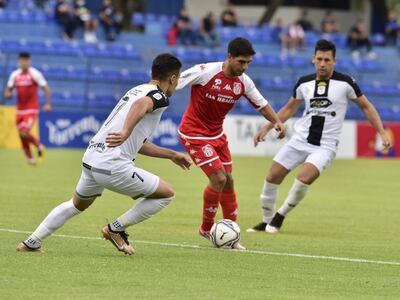 Franco Costa (c), futbolista de General Caballero de Juan León Mallorquín, presionado por dos rivales en el choque contra Tacuary por la quinta fecha del torneo Apertura 2023 del fútbol paraguayo.