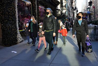 Personas con máscaras protectoras caminan junto a las ventanas navideñas en Saks Fifth Avenue el 29 de noviembre de 2020 en la ciudad de Nueva York.