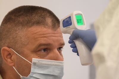 Un trabajador médico controla la temperatura de un paciente en el Hospital Kutvolgyi de Budapest, Hungría.