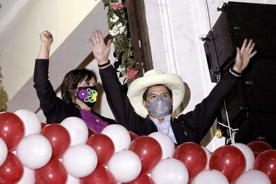 El presidente electo de Perú, Pedro Castillo (d), junto a su vicepresidenta Dina Boluarte, saludan a sus simpatizantes desde un balcón en la Plaza San Martín, luego de recibir las credenciales de sus cargos hoy, en Lima (Perú).