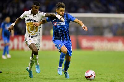 El paraguayo Ángel Romero (d), del Cruz Azul, intenta zafarse de la marca del ecuatoriano Washington Corozo, de Pumas, durante el partido que empataron sin goles.