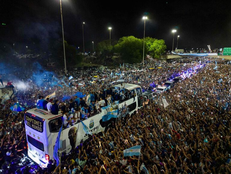Los jugadores de la selección de Argentina a bordo del bus descapotable durante el recorrido hasta el predio de Ezeiza en compañía de miles y miles de argentinos, que recibieron al plantel en el Aeropuerto Internacional de Ezeiza después de la conquista del Mundial Qatar 2022. 