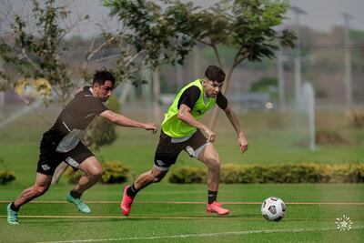 Iván Piris sale a la caza e Julio César Enciso, en el entrenamiento gumarelo, en Luque.