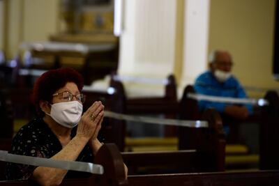 Una mujer ora esta mañana durante la misa en la Catedral Metropolitana de Asunción. Como medida de prevención contra la expansión del coronavirus, varios bancos están clausurados y los espacios para sentarse y formar fila están demarcados.
