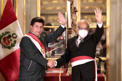 El presidente de Perú, Pedro Castillo (i), estrecha la mano al nuevo primer ministro, Aníbal Torres(d), después de que Torres jurara el cargo en una ceremonia celebrada en la noche del martes en el Palacio de Gobierno de Lima (Perú).