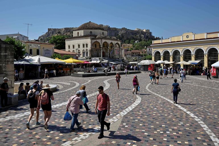Locales y turistas recorren la plaza Monastiraki en el centro de Atenas, Grecia.