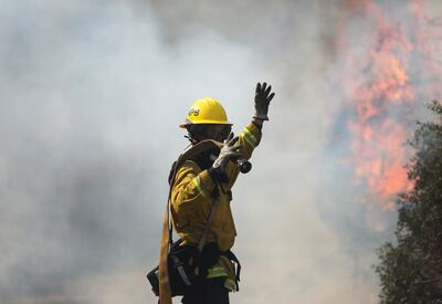 Un bombero participa de los intentos por combatir un incendio en Orange County, California, este lunes.