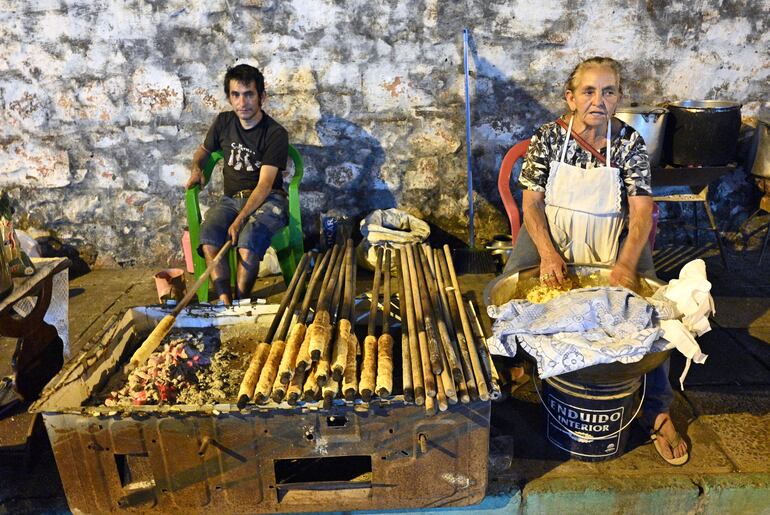 Doña Margarita Benítez de Chaparro prepara su chipa caburé o asador en las cercanías de la Basílica. 