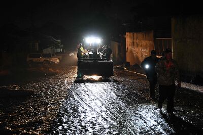 Los equipos de rescate se ven en una calle inundada después de un deslizamiento de tierra debido a las fuertes lluvias en El Castaño, Venezuela, el 17 de octubre de 2022.