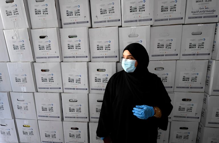 Una voluntaria con mascarilla y guantes participa de una campaña de entrega de alimentos impulsada por el jeque de Dubái, Hamdan bin Mohamed Al Maktoum.