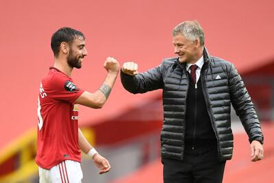 Manchester United's Norwegian manager Ole Gunnar Solskjaer (R) congrtulates Manchester United's Portuguese midfielder Bruno Fernandes during the English Premier League football match between Manchester United and Bournemouth at Old Trafford in Manchester, north west England, on July 4, 2020. (Photo by PETER POWELL / POOL / AFP) / RESTRICTED TO EDITORIAL USE. No use with unauthorized audio, video, data, fixture lists, club/league logos or 'live' services. Online in-match use limited to 120 images. An additional 40 images may be used in extra time. No video emulation. Social media in-match use limited to 120 images. An additional 40 images may be used in extra time. No use in betting publications, games or single club/league/player publications. / 