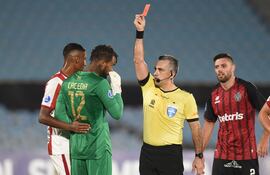 El árbitro paraguayo Carlos Paúl Benítez le exhibe la tarjeta roja al arquero peruano Carlos Cáceda, quien cortó un ataque de River tocando el balón afuera de su área.