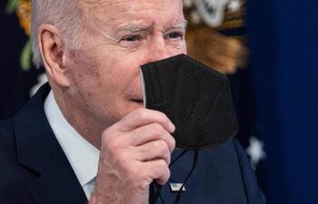 El presidente de EE. UU., Joe Biden, sostiene una máscara N95.