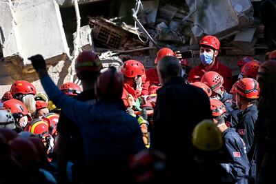 Rescatistas llevan en camilla a una víctima del terremoto que fue rescatada de entre los escombros de un edificio derrumbado en Esmirna, Turquía.