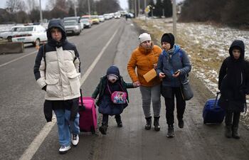 Una familia ucraniana camina hacia el cruce fronterizo Medyka-Shehyni entre Ucrania y Polonia mientras huyen del conflicto en su país.