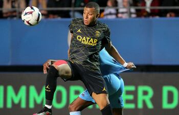 Kylian Mbappé intenta controlar el balón ante la marca de un jugador del Troyes, durante el partido que París SG ganó ayer por 3-1.