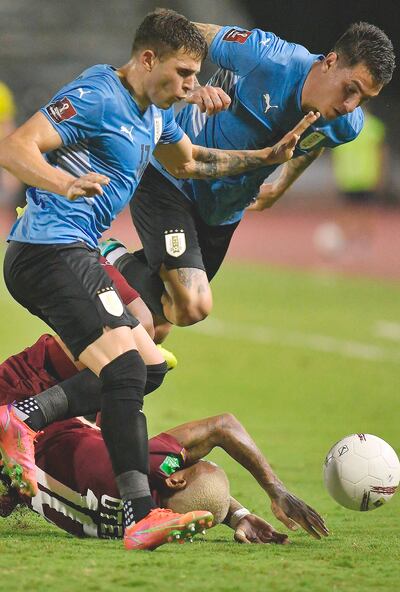 El venezolano Rómulo Otero van al  piso tras un choque con los charrúas González y Giménez.