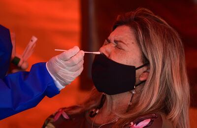 A woman is tested for the novel coronavirus disease, COVID-19, at a screening drive-thru in Asuncion on December 27, 2021, after Paraguayan health authorities confirmed the first three cases of the Omicron variant in the country. (Photo by Norberto DUARTE / AFP)