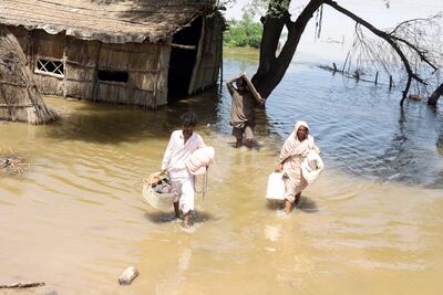 Habitantes evacúan una zona inundada en el distrito de Jamshoro, en la provincia de Sindh, Pakistán.