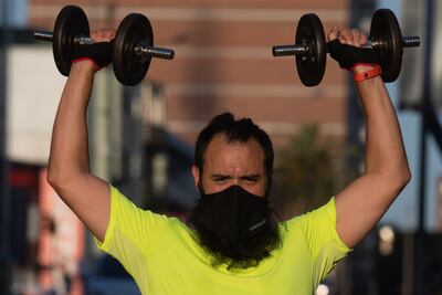 Un hombre con mascarilla levanta pesas en un parque en Montevideo, Uruguay, luego de que el gobierno ordenara el cierre de gimnasios ante el aumento de casos de la enfermedad.